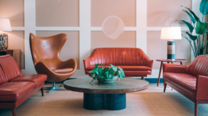 A modern living room with a stylish arrangement of leather sofas, an iconic Egg Chair, and a round coffee table.